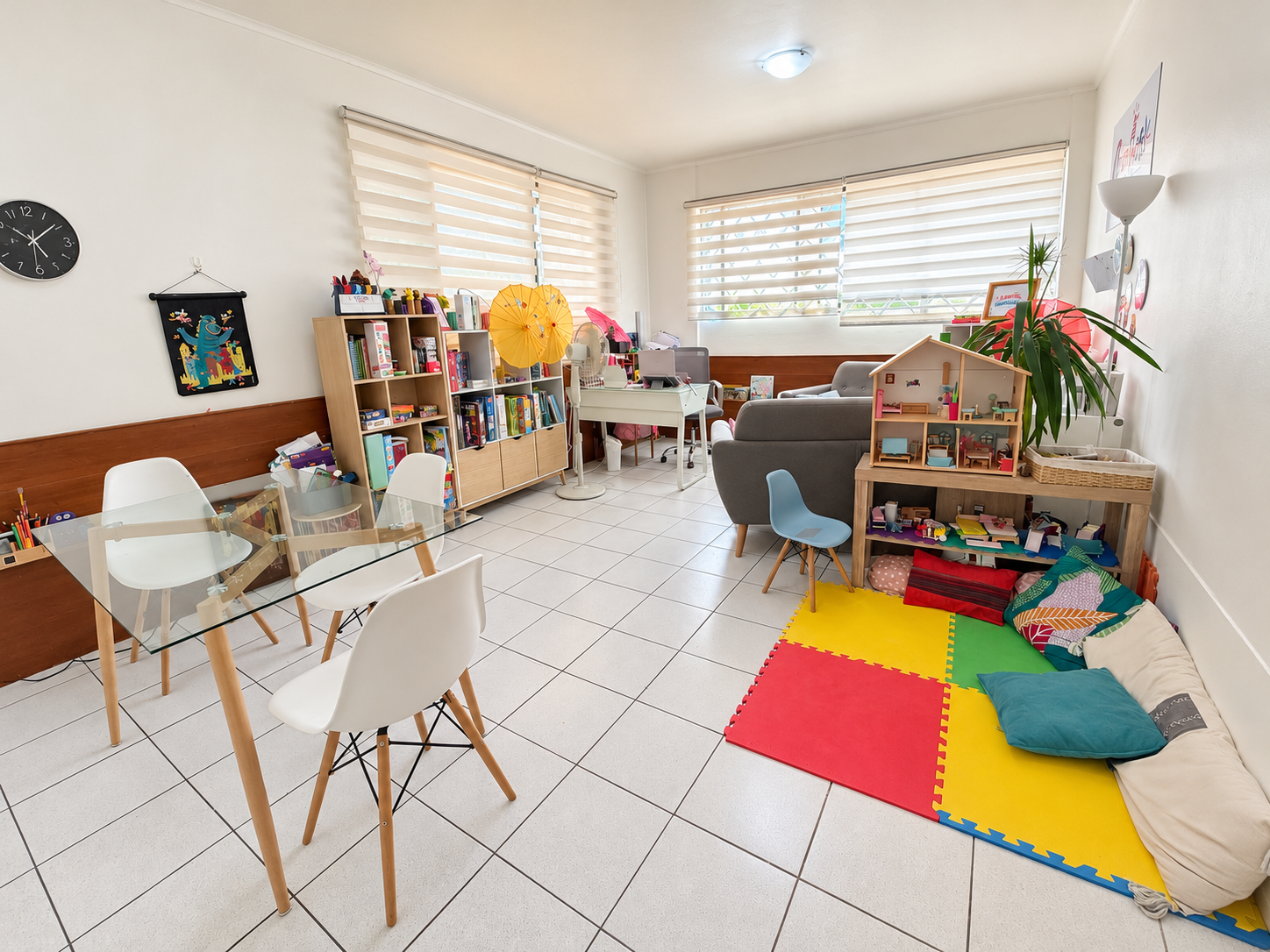 Sala de terapia de Kidsandfamily con juegos, libros, mesa y sillones